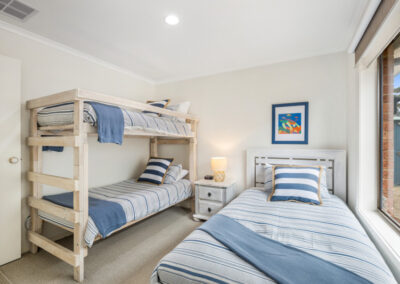 Bedroom with single bed and bunks at the Air BNB Safety Beach, Victoria